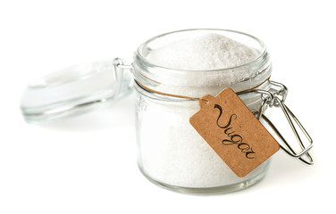 Opened glass jar with sugar. Isolated on white.