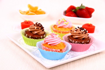 Four appetizing cupcakes on white plate