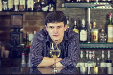 young man working as a bartender in a nightclub bar