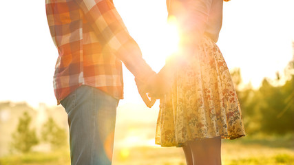 Young couple in love walking in the autumn park holding hands