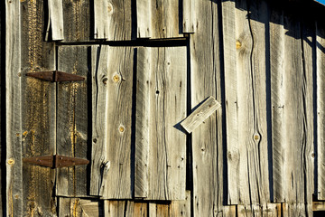 Old weathered barn door with rusty hinges