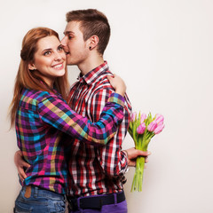 Young couple in love make a heart and hands are holding bouquet