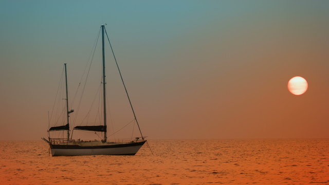 Yacht at anchor in the bay. Sunset on the tropical ocean