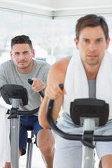 Determined man using exercise bike