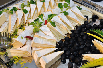 decorative tray with cheese and black olives