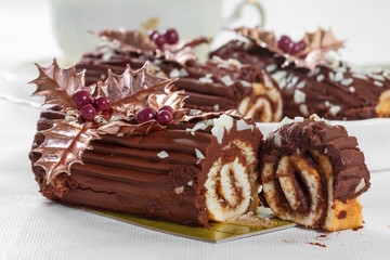 Chocolate roll with the decoration of leaves and berries