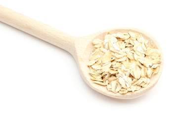 Heap of oatmeal with wooden spoon on white background