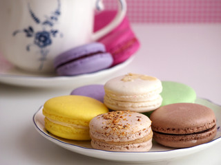Macaroons on plate and cup in background
