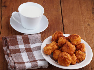 Homemade fritters and cup of milk