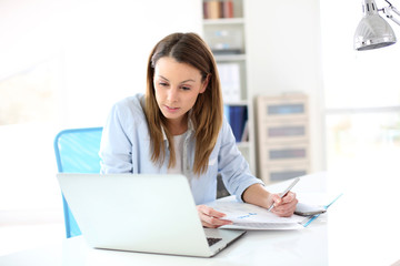 Businesswoman working in office on laptop