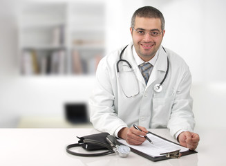 Arabian doctor in his office writing notes in his office.