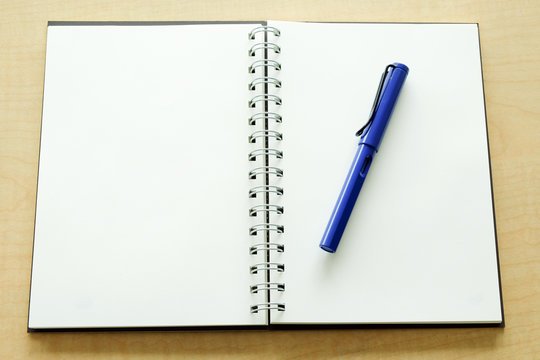 Notebook and blue pen