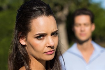 Woman with blurred man in background outdoors