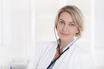 Portrait einer Ärztin auf Hintergrund weiß mit Blutdruckmeßgerät