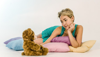 Young girl on a bed with a teddy bear