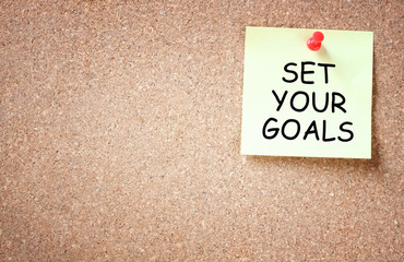 set your goals concept. sticky pinned to corkboard