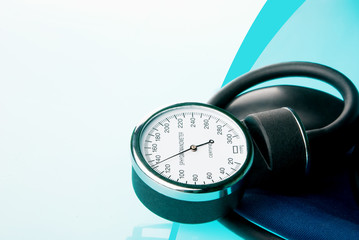 Sphygmomanometer on blue, reflective background