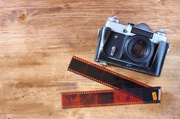 old vintage camera and pictures over wooden background