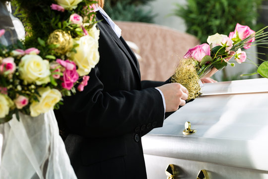Frau auf Beerdigung mit Sarg