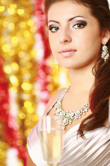 Beautiful young brunette woman drinking champagne