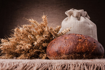 Loaf of bread and rye ears still life