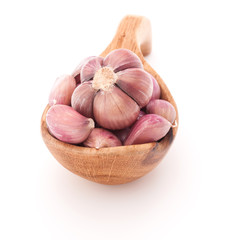 Garlic cloves in wooden bowl isolated on white background