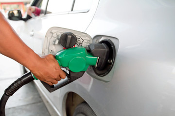 close up of man hand putting gas into the car at gas station