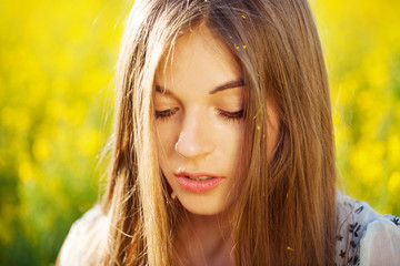 Fototapeta premium Beautiful girl with long hair in yellow flowers