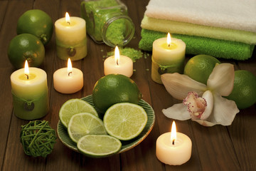 Fototapeta na wymiar still life with limes and candles on a wooden board