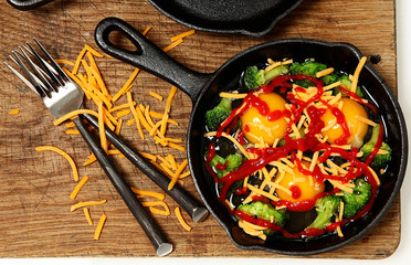 Uncooked Raw Eggs in Skillet with Brocolli, Cheese and Sriracha
