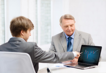 older man and young man with laptop computer