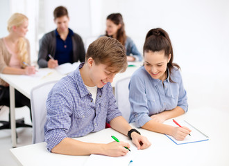 smiling students with notebooks at school