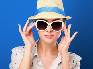 Young woman in hat and sunglasses , isolated on blue background.