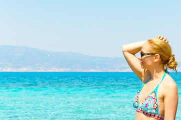 Naklejka premium Beautiful young woman in swimsuit, relaxing on a sunny beach