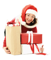 Happy girl in santa hat with pile of xmas gifts