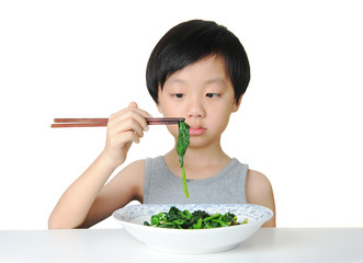 Young boy eating vegetables