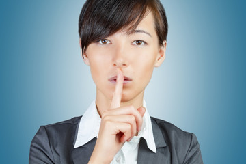 Business woman makes silence gesture