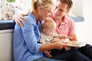 Parents Reading Book To Young Son