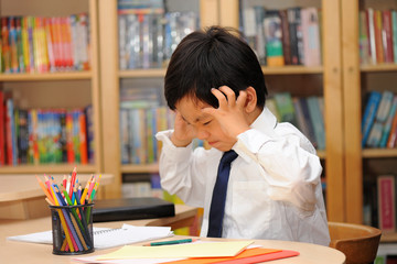 Frustrated Asian schoolboy in school uniform