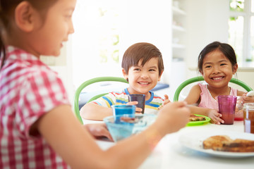 Obraz na płótnie Canvas Three Asian Children Having Breakfast Together In Kitchen