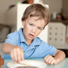 boy makes a cake in kitchen