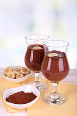 Cocktails with banana and chocolate on table on light