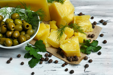 Parmesan cheese, fresh herbs and olives on wooden background