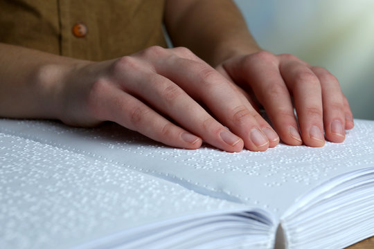 Blind woman read book written in Braille