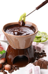 Chocolate fondue with marshmallow candies and fruits, isolated