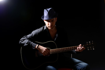 Young musician playing acoustic guitar and singing,
