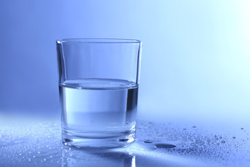 Water in  glass, on dark blue background