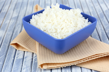Cooked rice in bowl on wooden background