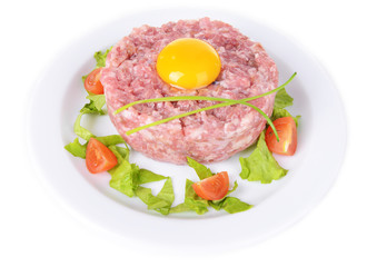 Delicious steak tartare with yolk on plate isolated on white