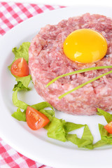 Delicious steak tartare with yolk on plate on table close-up